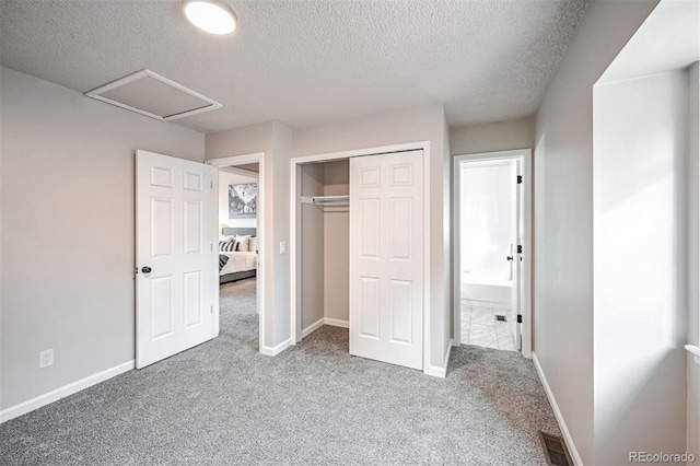 1470 S Quebec Way Unit 62, Denver, CO 80231 - unfurnished bedroom with carpet flooring, a textured ceiling, attic access, a closet, and baseboards