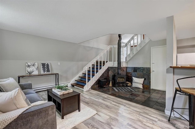 891 Fairview Blvd Unit 20, Breckenridge, CO 80424 - living room with stairway, wood finished floors, a wood stove, and baseboard heating