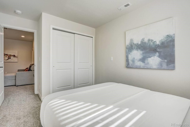 bedroom with light carpet and a closet