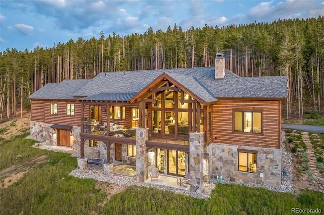 242 Point View Pl, Breckenridge, CO 80424 - back of property with a view of trees, stone siding, a patio, and a chimney