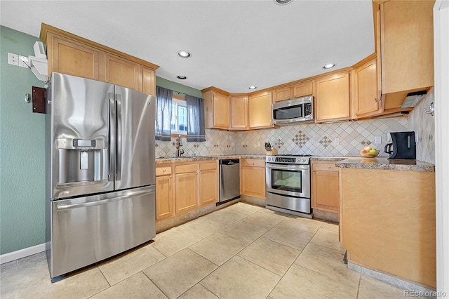 kitchen featuring light brown cabinetry, light tile patterned floors, decorative backsplash, and stainless steel appliances