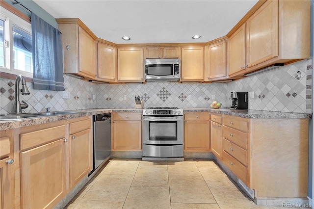 kitchen featuring light brown cabinetry, sink, backsplash, and stainless steel appliances