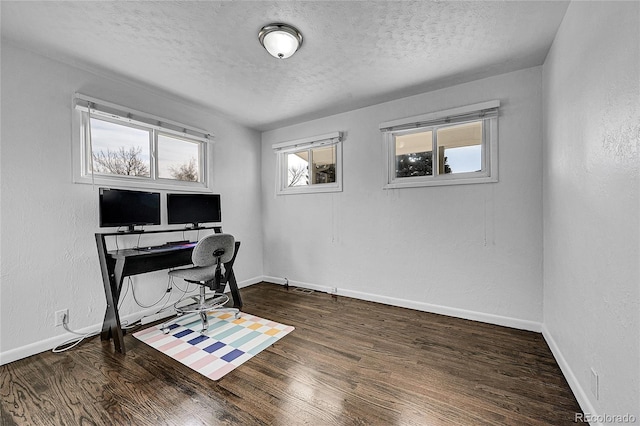 home office with dark hardwood / wood-style flooring and a textured ceiling