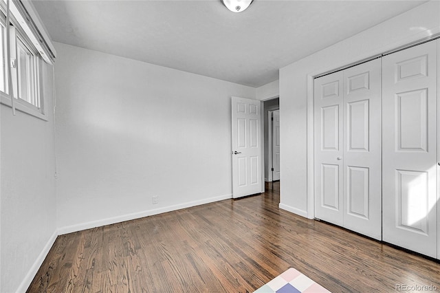 unfurnished bedroom featuring dark wood-type flooring and a closet