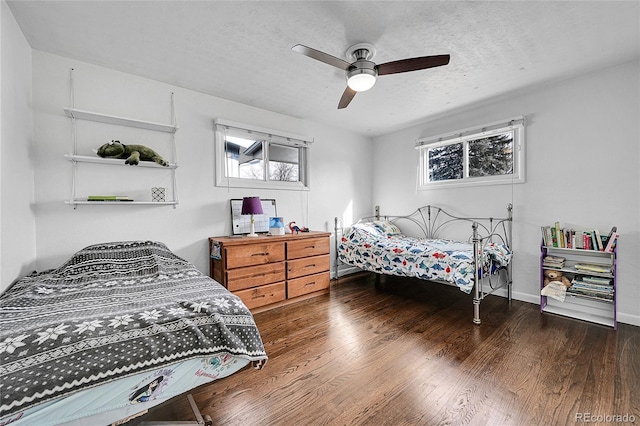 bedroom featuring multiple windows, ceiling fan, dark hardwood / wood-style floors, and a textured ceiling