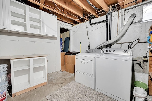 clothes washing area featuring cabinets and separate washer and dryer