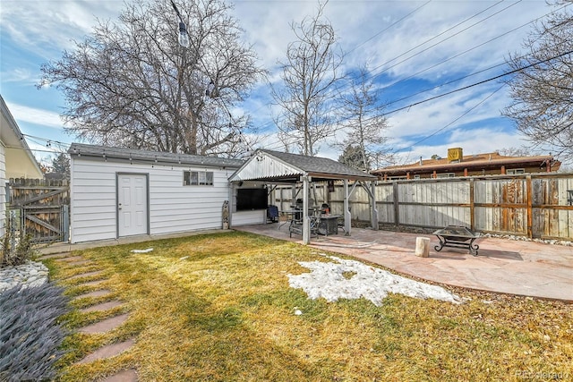 view of yard with a fire pit, a storage unit, and a patio area