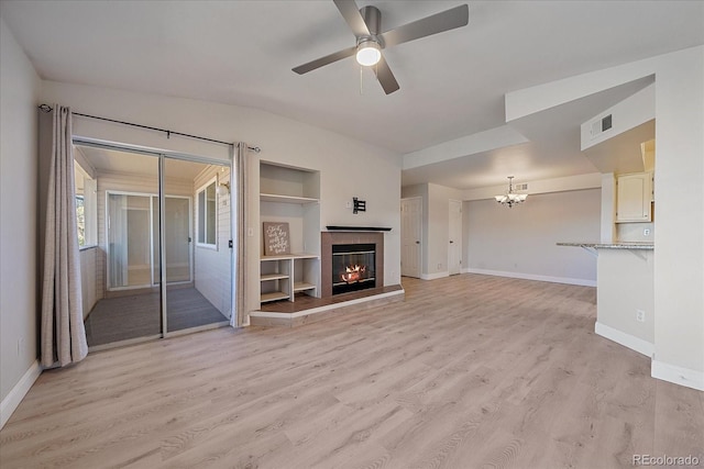 unfurnished living room featuring light hardwood / wood-style floors and ceiling fan with notable chandelier