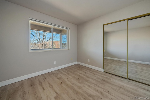 unfurnished bedroom featuring light wood-type flooring and a closet
