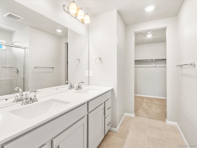 17487 E 89th Way, Commerce City, CO 80022 - full bathroom featuring double vanity, a walk in closet, a stall shower, baseboards, and tile patterned floors