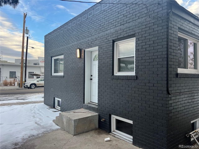 doorway to property featuring brick siding