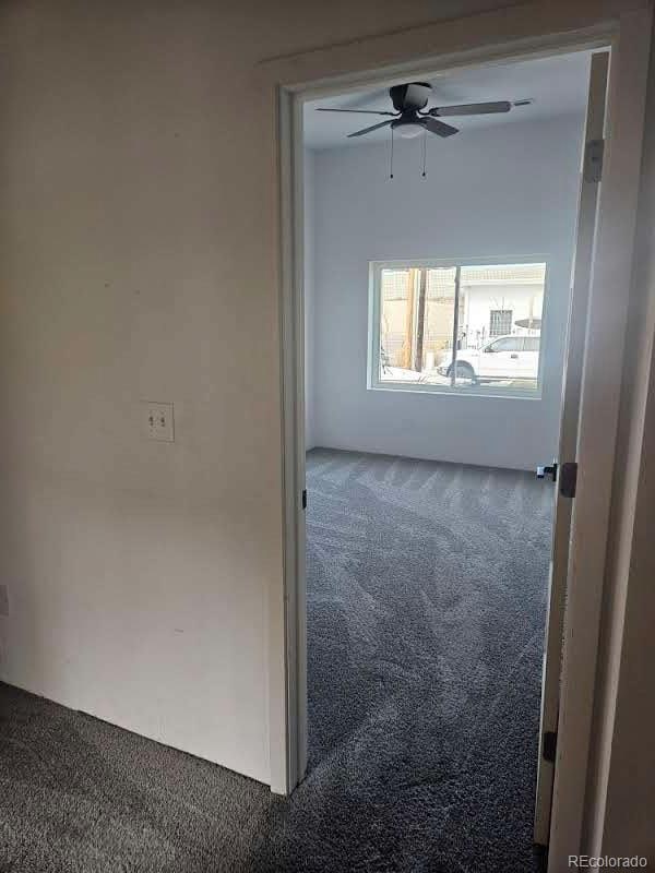 carpeted spare room with a ceiling fan