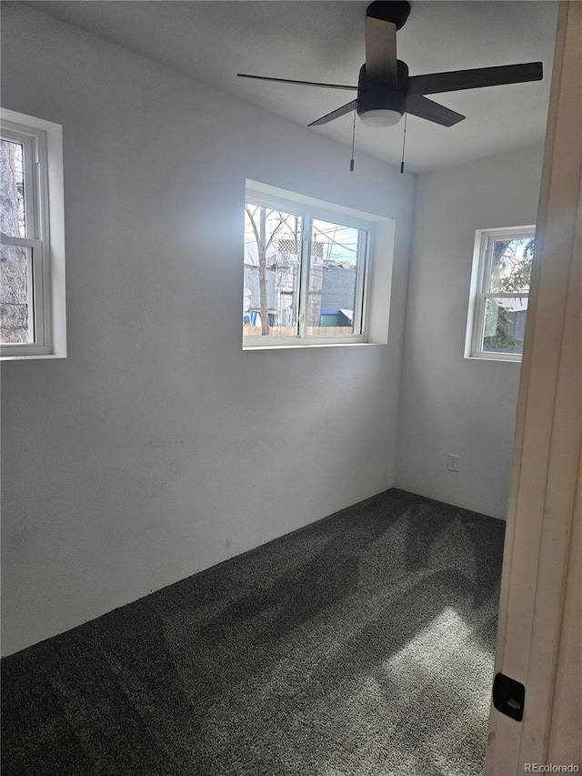 carpeted spare room featuring a ceiling fan