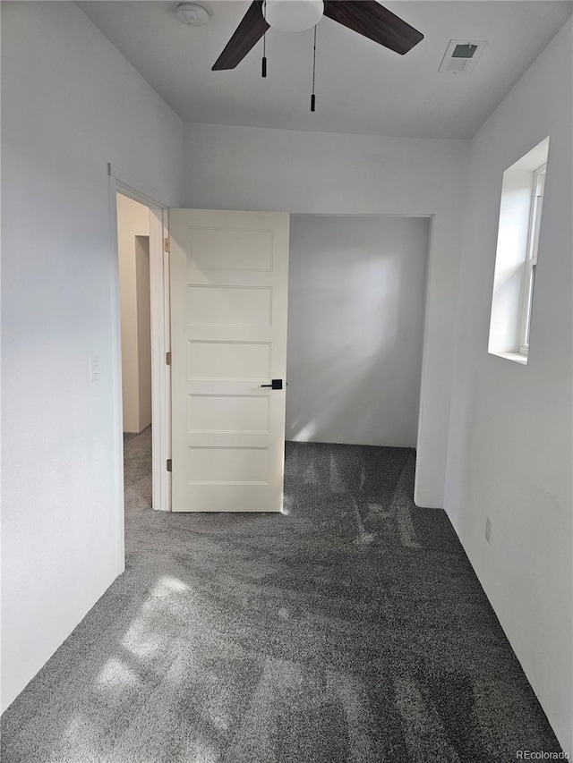 spare room featuring visible vents, carpet flooring, and a ceiling fan