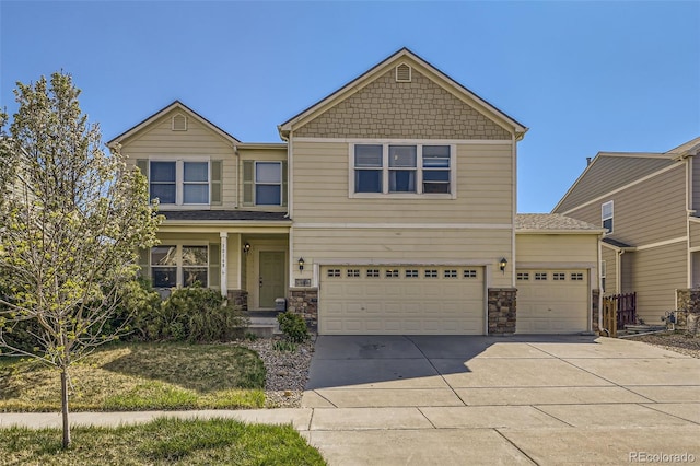 craftsman-style home with concrete driveway, stone siding, and a garage