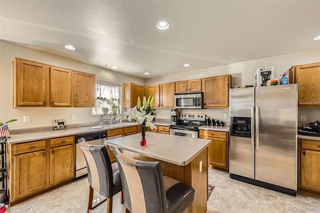 kitchen featuring stainless steel appliances, brown cabinets, light countertops, recessed lighting, and a textured ceiling