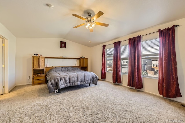 bedroom with light carpet, vaulted ceiling, baseboards, and a ceiling fan