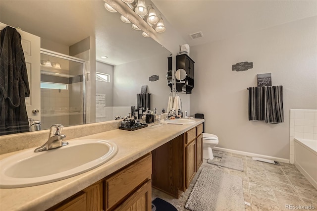 bathroom with baseboards, a stall shower, a bath, toilet, and double vanity