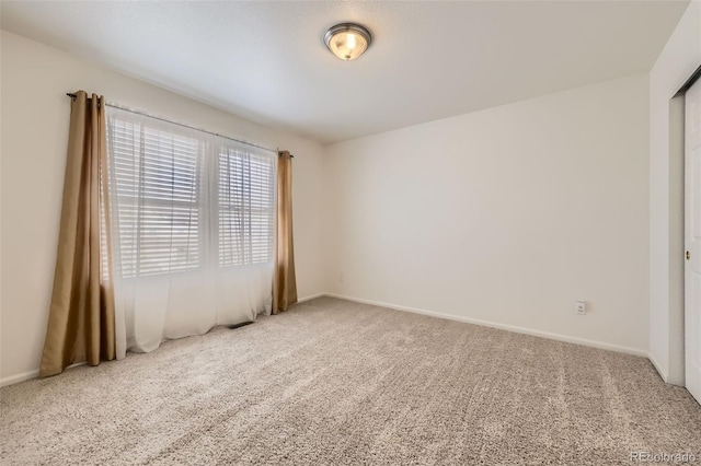 empty room with carpet and baseboards
