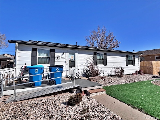 rear view of property with a yard and fence