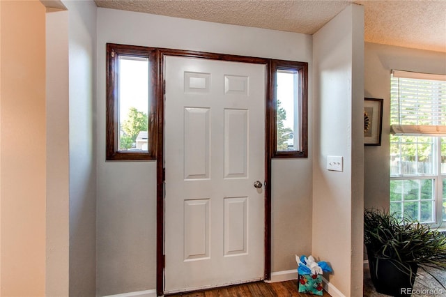 8538 W Glasgow Pl, Littleton, CO 80128 - foyer with plenty of natural light, a textured ceiling, and dark wood-style floors