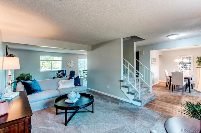 8538 W Glasgow Pl, Littleton, CO 80128 - living room featuring stairs, a textured ceiling, a chandelier, and carpet flooring