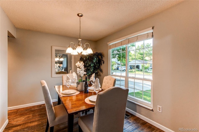 8538 W Glasgow Pl, Littleton, CO 80128 - dining area featuring dark wood finished floors, a chandelier, and a textured ceiling
