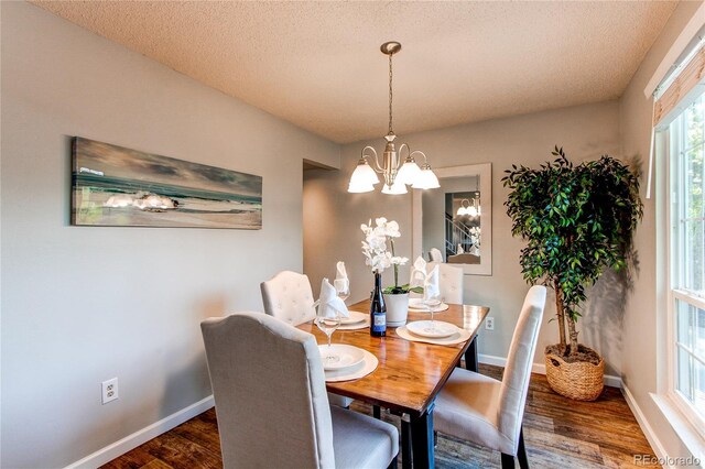 8538 W Glasgow Pl, Littleton, CO 80128 - dining space featuring a chandelier, wood finished floors, and a textured ceiling