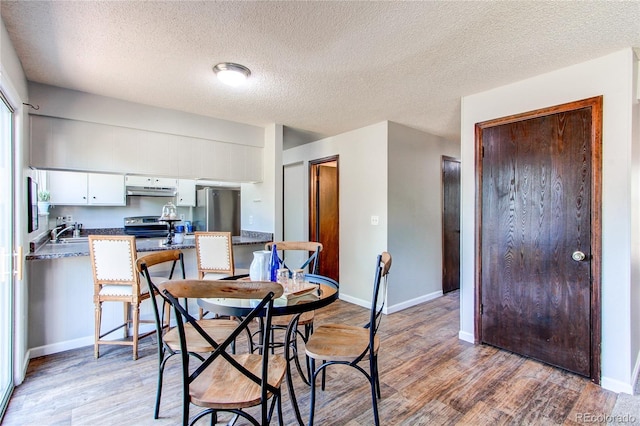 8538 W Glasgow Pl, Littleton, CO 80128 - dining area with light wood-style flooring and a textured ceiling