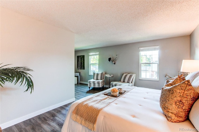 8538 W Glasgow Pl, Littleton, CO 80128 - bedroom featuring multiple windows, dark wood-style floors, and a textured ceiling