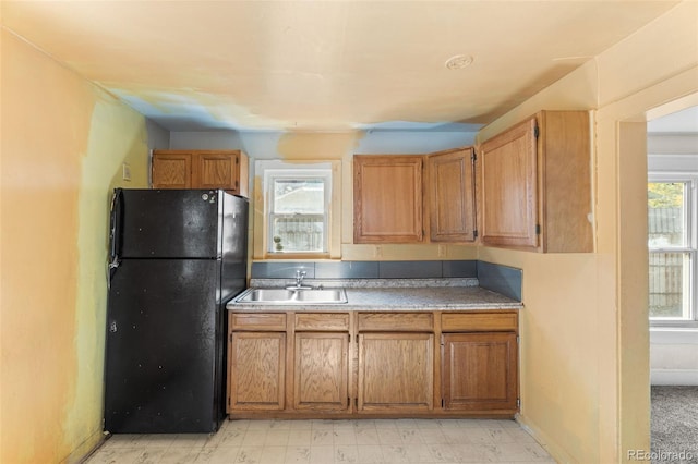 kitchen featuring sink and black refrigerator