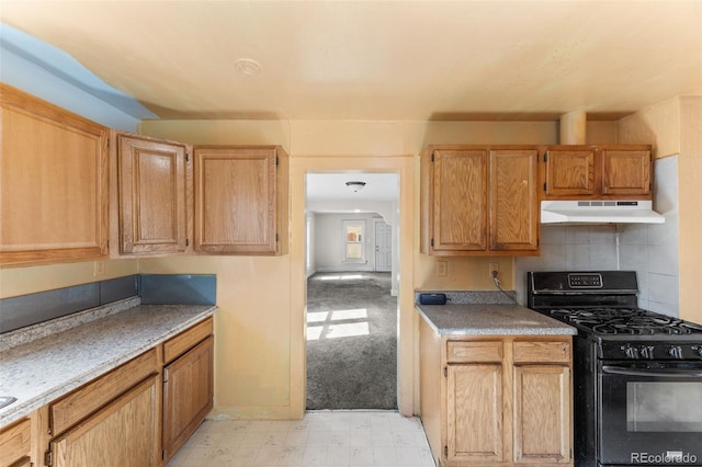 kitchen featuring black range with gas stovetop, light carpet, light brown cabinets, and tasteful backsplash