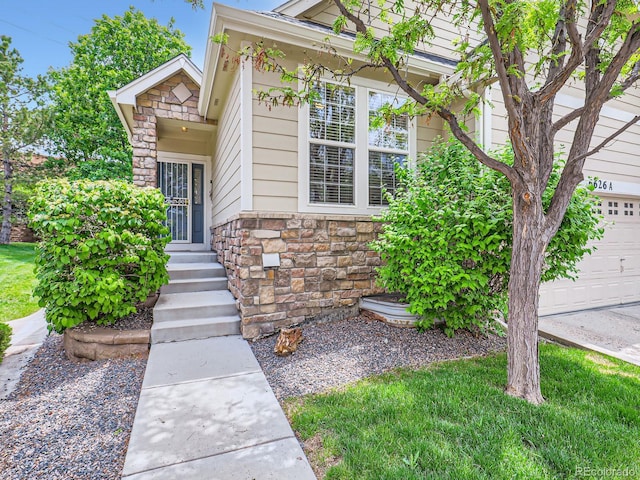 6626 S Reed Way Unit A, Littleton, CO 80123 - doorway to property with stone siding and a garage