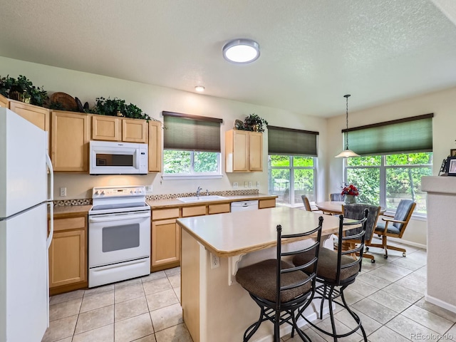 6626 S Reed Way Unit A, Littleton, CO 80123 - kitchen featuring white appliances, light brown cabinetry, light countertops, healthy amount of natural light, and a textured ceiling