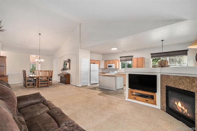 6626 S Reed Way Unit A, Littleton, CO 80123 - living area featuring light carpet, a chandelier, high vaulted ceiling, and a fireplace