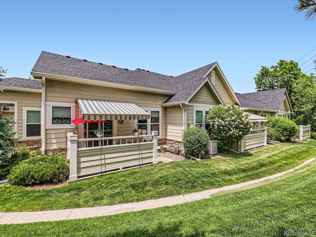 6626 S Reed Way Unit A, Littleton, CO 80123 - view of front of home featuring a front yard, stone siding, and a shingled roof