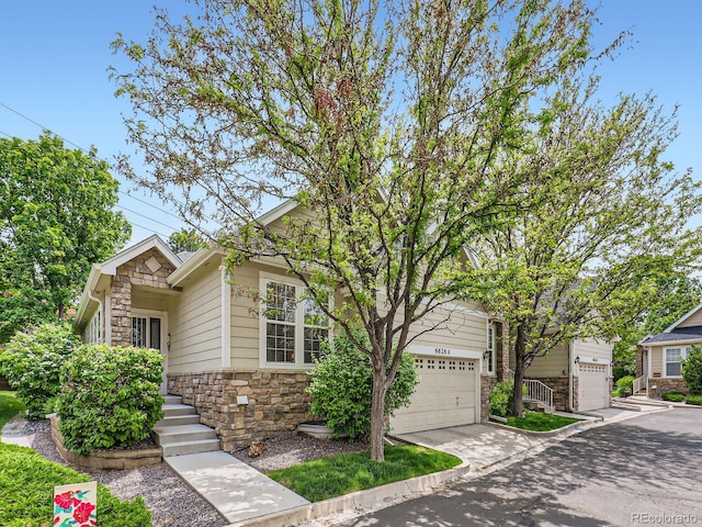 6626 S Reed Way Unit A, Littleton, CO 80123 - view of front facade featuring stone siding, concrete driveway, and a garage