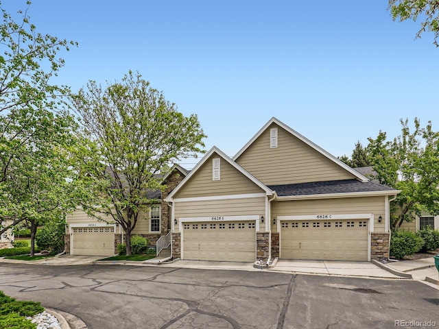 6626 S Reed Way Unit A, Littleton, CO 80123 - view of front facade featuring stone siding, an attached garage, and a shingled roof