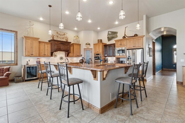 kitchen with a spacious island, appliances with stainless steel finishes, a breakfast bar, and hanging light fixtures