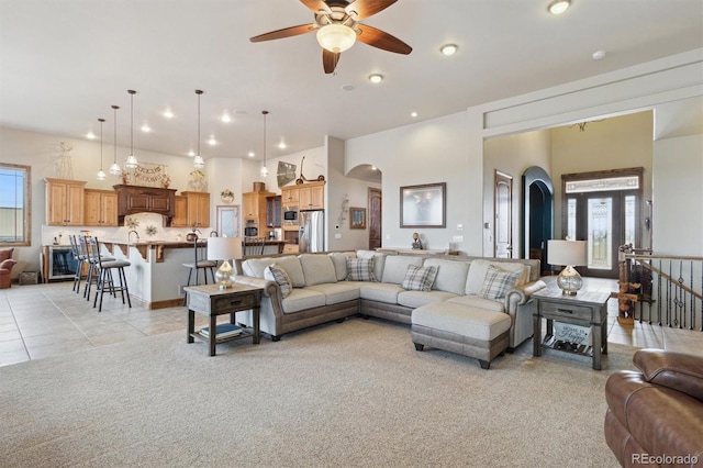 tiled living room featuring ceiling fan and a high ceiling