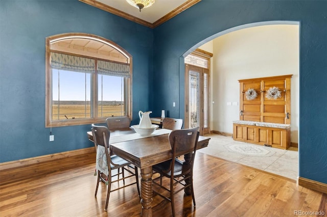 dining area featuring ornamental molding and light hardwood / wood-style flooring