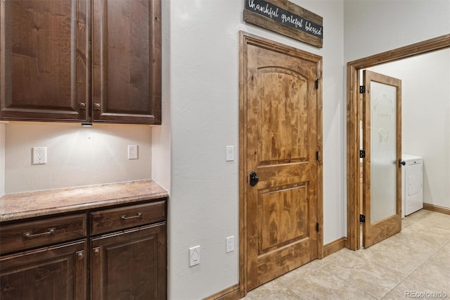 kitchen with dark brown cabinetry and washer / dryer