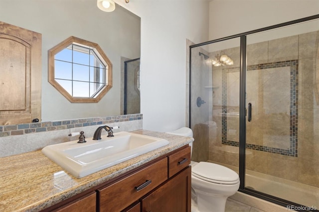 bathroom featuring vanity, toilet, and an enclosed shower