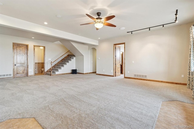 unfurnished living room featuring light carpet, rail lighting, and ceiling fan