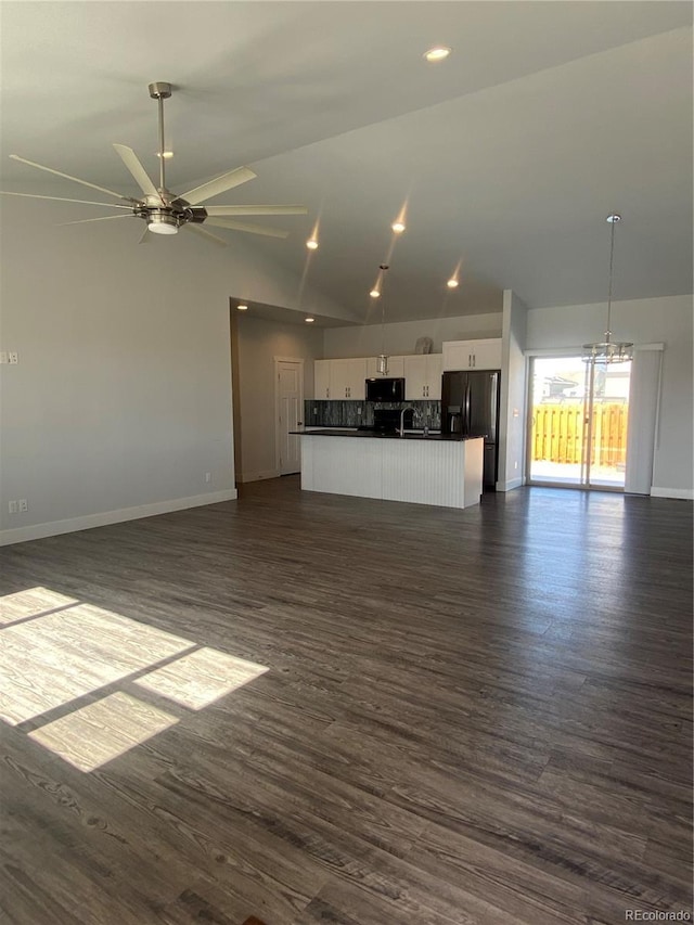 129 Red Tail Blvd, Buena Vista, CO 81211 - unfurnished living room featuring baseboards, a sink, dark wood-style floors, vaulted ceiling, and a ceiling fan
