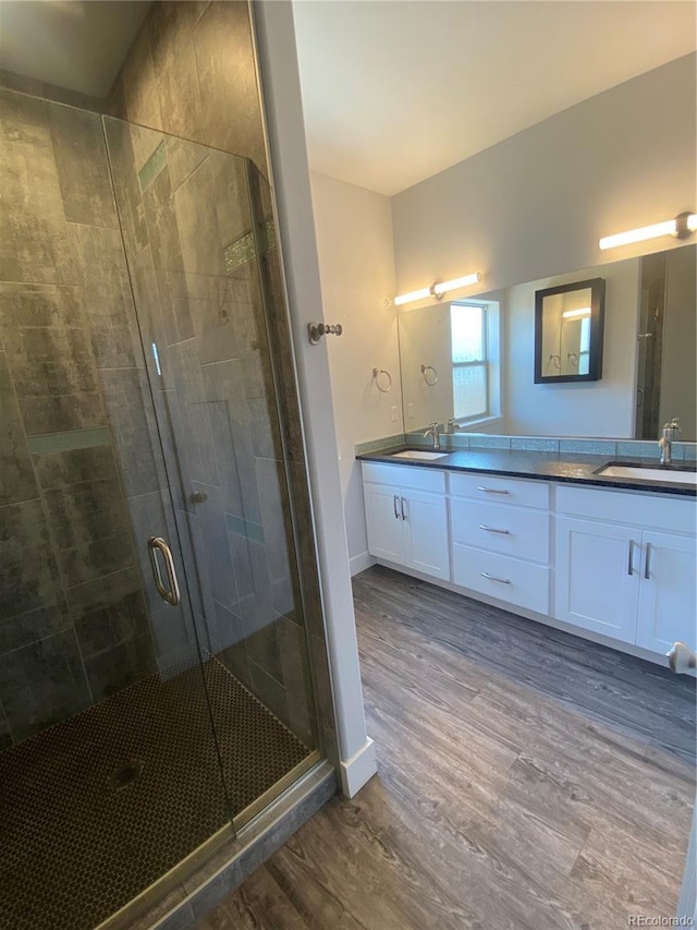 129 Red Tail Blvd, Buena Vista, CO 81211 - bathroom featuring wood finished floors, a shower stall, double vanity, and baseboards