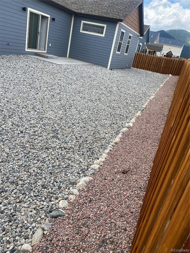 129 Red Tail Blvd, Buena Vista, CO 81211 - back of property featuring roof with shingles, fence, and a patio