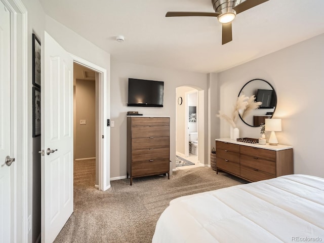 bedroom with light carpet, ensuite bath, and ceiling fan