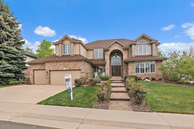traditional-style house with concrete driveway, brick siding, and a front lawn