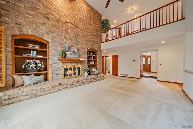 unfurnished living room featuring a ceiling fan, a towering ceiling, baseboards, carpet floors, and built in shelves
